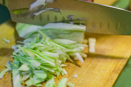 chopping cabbage on the Board male hands cooking vegetablesの写真素材