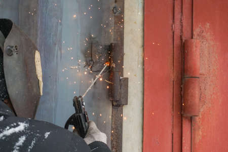 welding a man repairs a garage outdoorsの写真素材