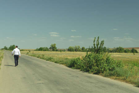 businessman walking on the road in white shirt and trousersの写真素材