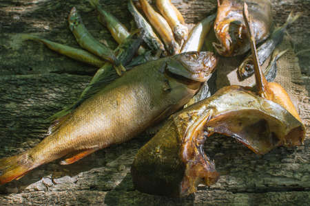 cold smoked fish on wooden background in rustic style