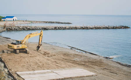 excavator digging on the beach construction of beachの写真素材