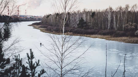first winter ice man fisherman on the river suburb Siberia