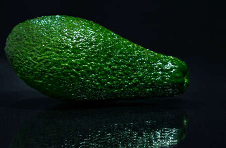 avocado green on black background close-up of healthy fruitの写真素材