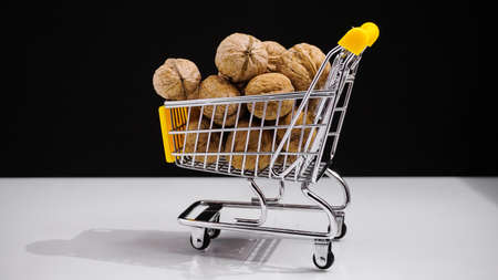 concept shopping cart with walnuts on white background, diet food. Health foodの写真素材