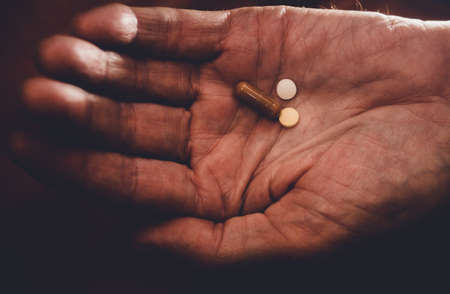 pills in the hand of an old man old age medicine help the elderly