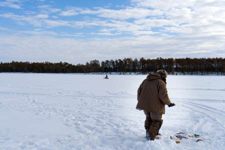 a fisherman holds the ice-fishing catch big fish bass. winter sport.の写真素材