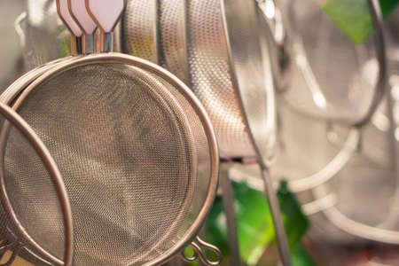 kitchen utensils in the form of a small pot or bucket with holes on the bottom in a retail storeの写真素材