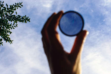 polarizing filter in the hand accessory for the camera contrast of the skyの写真素材