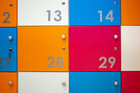 Luggage storage for things. Cells in white, orange, red, blue with metal handles and locks. Cells numbered with metal numbers. Temporary storage of things.の写真素材