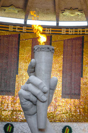 Volgograd, Russia-June 25, 2019: Hall of Military Glory. In centre of hall is a sculpture of hand holding torch with Eternal Fire vertical photoのeditorial素材