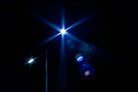 city lighting poles off the road, evening landscape. light of a lantern on a black background at night. concept of a burning street lamp. one lantern on the sky backgroundの写真素材