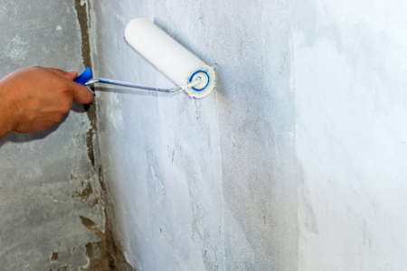 paints an old concrete wall with a rollerの写真素材