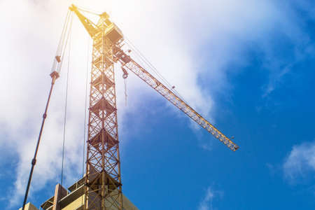 Buildings under construction and cranes under a blue sky. Bright Sunny day, construction of high-rise buildings.の写真素材