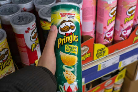 Tyumen, Russia - November 20, 2019: Pringles chips with onions and cheese green jar, buying snacks...