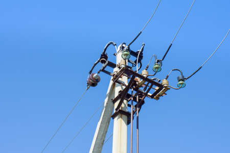 Metal power tower with high-voltage cables against the blue sky. Communication, electricity.の写真素材