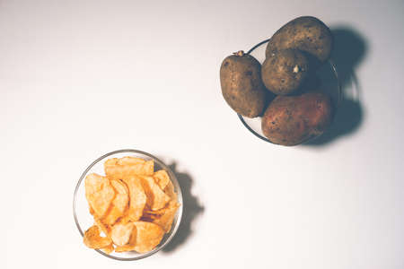 Crispy potato chips in a bowl on a white background, top view. natural potatoesの写真素材
