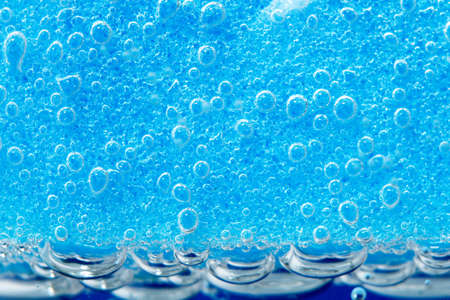 blue background is a sponge for washing dishes. bubbles, under water. porous macro spongeの写真素材
