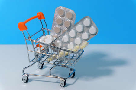 package medicine or pills in miniature shopping cart with copy space. the concept of buying pills, medical businessの写真素材