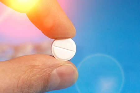 tablet pill in hand close-up selective focus. concept of medicine, medicine. on a blue background.