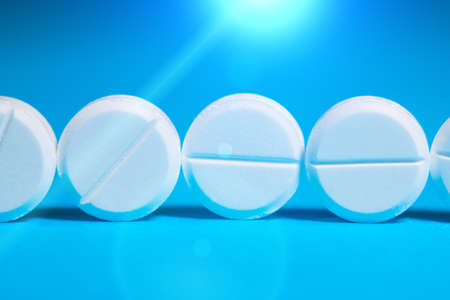 white pill on blue background macro photo - concept of medicine and medication treatment, health...