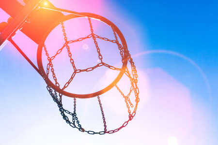 Basketball hoop against blue cloudy sky with copy space.