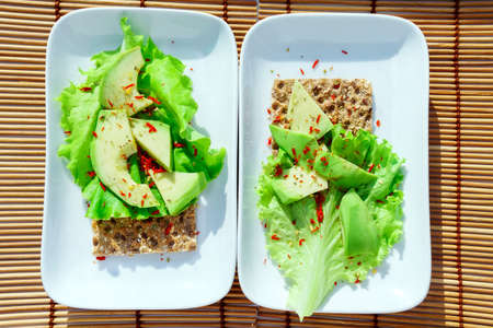 crispbread with salad and avocado on a white plate top view. Healthy healthy diet Breakfast for twoの写真素材