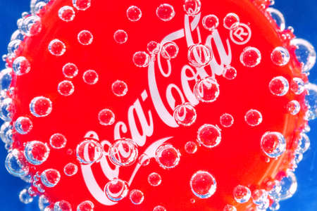 Tyumen, Russia-June 11, 2020: Coca-Cola cap in bubbles on a black background. Low key and soft...