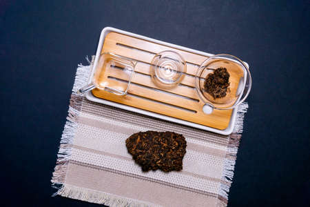 Asian pressed pu-erh tea, shu puer herbal on dark background top view. flat layの写真素材