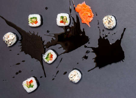 sushi with soy sauce pickled ginger, served on stone background. Top view, flat lay.