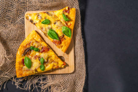 Two slice pizza basil leaves on black background, top view. flat lay. space for copying text