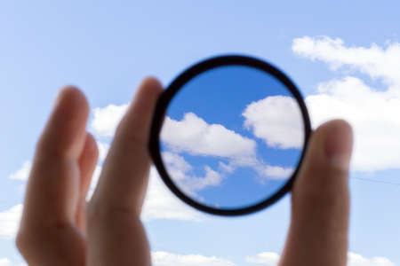 man holding a photo filter. photo accessory increases image contrast and removes glare from the sunの写真素材