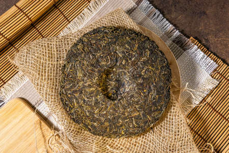 old Shen puerh chinese fermented tea on papyrus paper background. Top view. the Chinese dry the tea