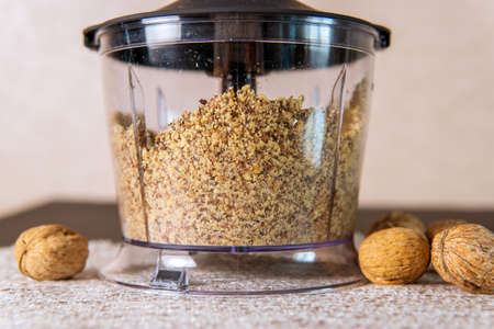 roasted peanuts in glossy plastic blender with gray metallic knife. Cooking of home made from...