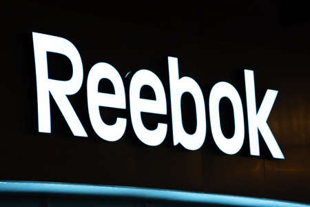 Tyumen, Russia-October 15 2020: Reebok sign on a black background at night. Reebok is an English footwear and apparel companyのeditorial素材