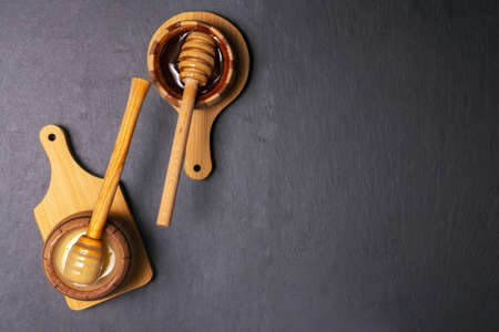 Honey in a jar On a black wooden background. Free space for text. Top view.