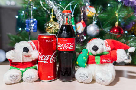 Tyumen, Russia-October 25, 2020: Bottle with coca cola at christmas background and white bear toys.のeditorial素材