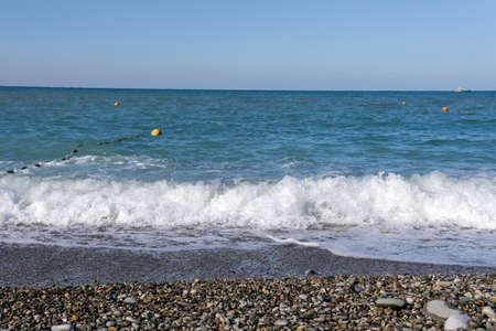 Pebbles on the beach close up on the sea surf background, copy space. the static camera