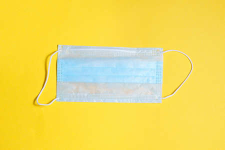 medical protective mask, on a yellow background Concept, fight, prevention, quarantine against coronavirus flu infection. Flat layの写真素材