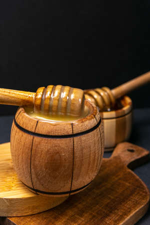 Sugar paste or beauty wax for sugaring flows from a wooden dipper. Honey drops from the spoon.の写真素材