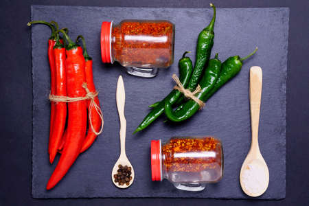 red and green hot chili pepper served in black plate on black background. Top viewの写真素材