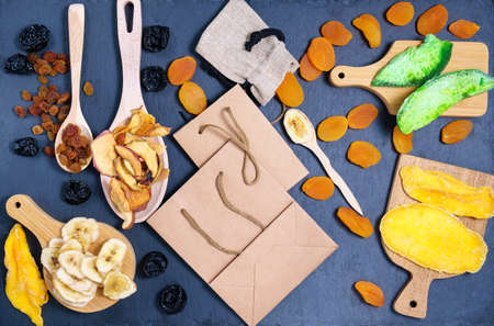Organic dried fruits craft eco packaging. dried apricots, raisins, mango, papaya, prunes, banana Vegetarian foodの写真素材