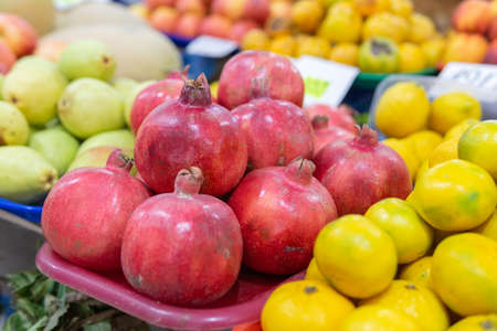 A lot of red pomegranates in the street market for sale. Juicy and tasty pomegranate fruitsの写真素材