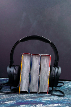 black headphones with a stack of books. The concept of audio books and modern educationの写真素材