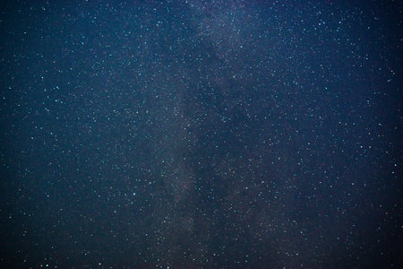 texture of the blue night sky and stars on a dark background. With noise and grain. Long-exposure...