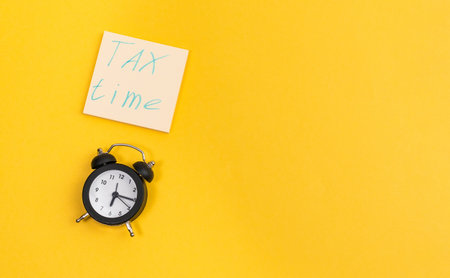 Pay taxes concept. Taxes word on office work on yellow background top view space for textの写真素材