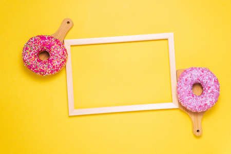 donuts with pink icing on a yellow background. Sweet, pastries. Calories, fat. buying sweets
