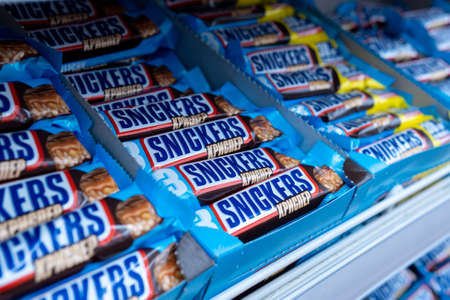Tyumen, Russia-February 26, 2021: Snickers is a chocolate bar with caramel and peanuts, manufactured by Mars, Incorporated.のeditorial素材