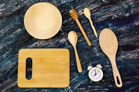 wooden kitchen utensils items on black background with clockの写真素材