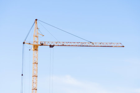 yellow construction crane on a blue sky background. space for copying text
