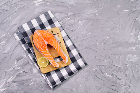 Raw Salmon steak on Grey concrete background. Preparation food, top view. Copy space